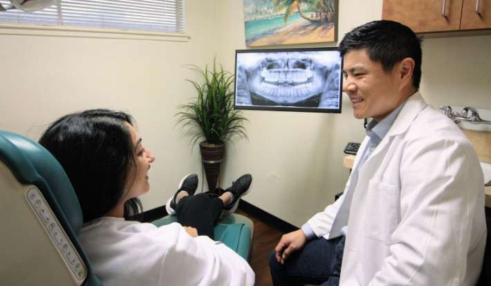 Dr. Eric Hsu reviewing X-rays with a dental patient